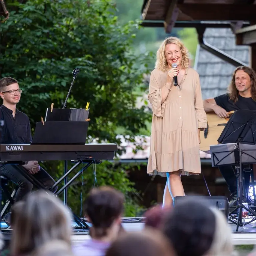 Živý koncert s hudebníky a zpěvačkou.